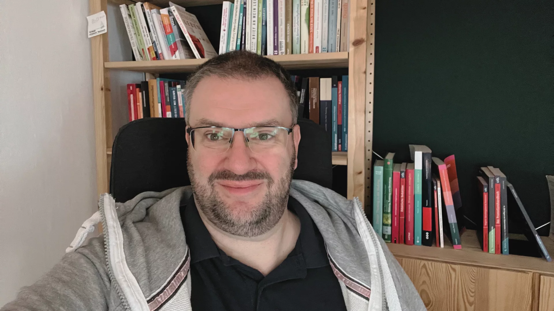 Heiko vor seinem Bücherregal