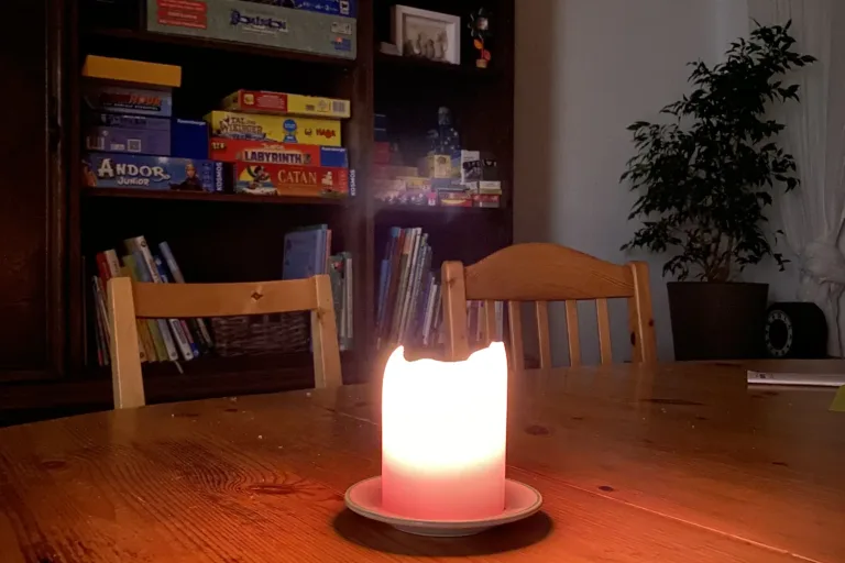 Brennende Kerze auf einem Holztisch am Abend - Heiko Metz