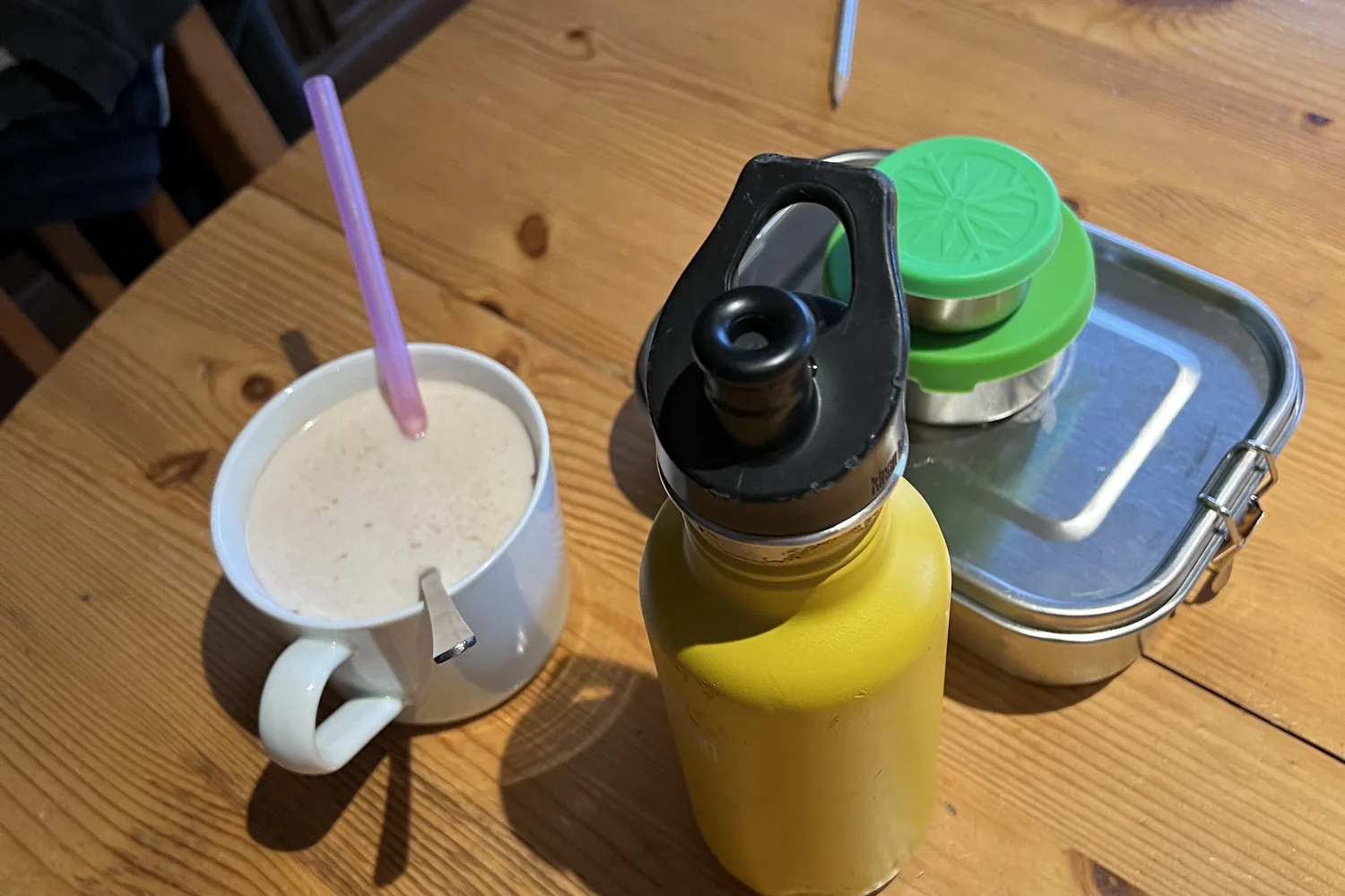 Tasse, Trinkflasche und Brotdose auf dem Küchentisch - Heiko Metz