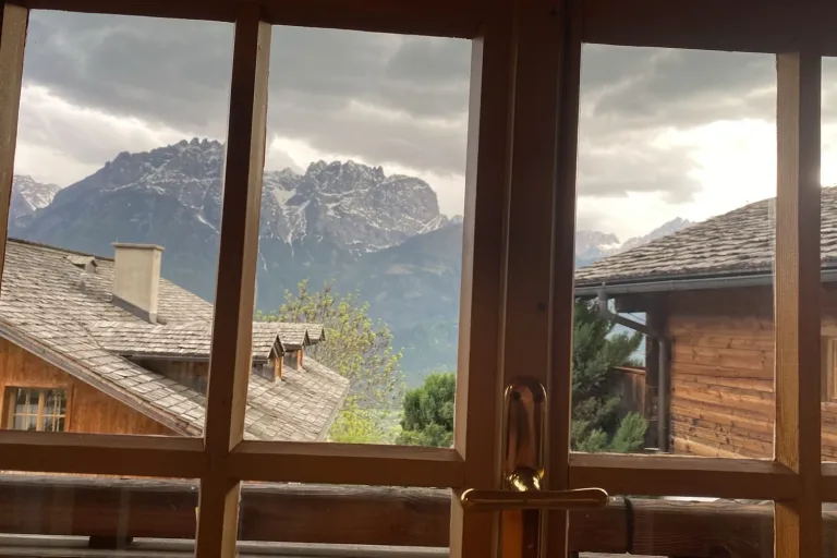 Blick durch ein Sprossenfenster auf eine Bergkette - Heiko Metz
