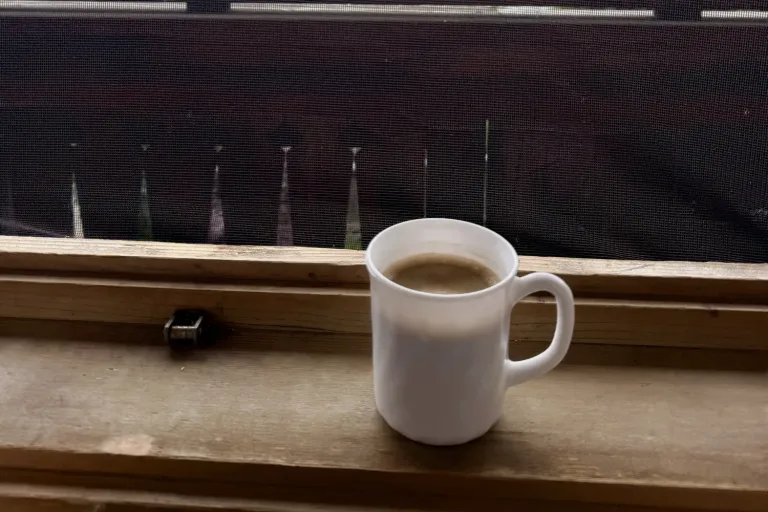 Weiße Tasse Kaffee auf einem Balkongeländer - Heiko Metz