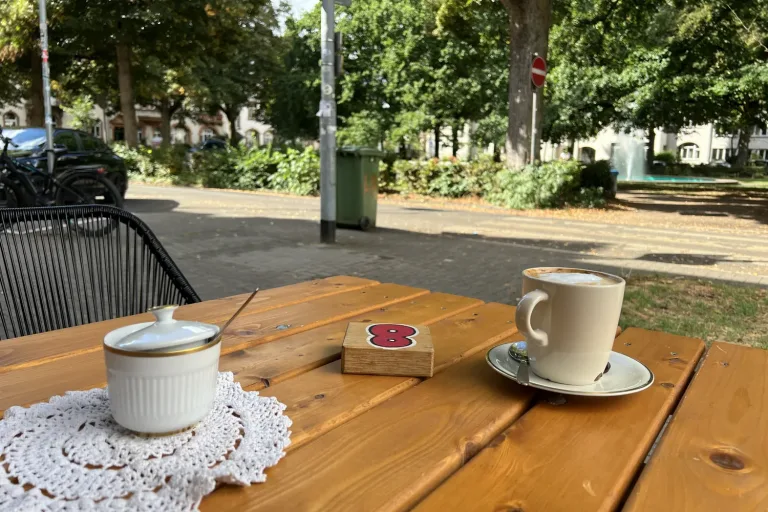 Zwei Tassen auf einem Holztisch im Straßencafé - Heiko Metz