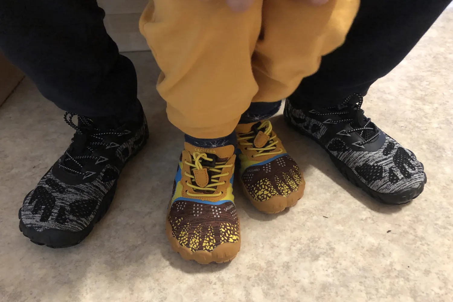 Erwachsenenschuhe neben gelben Kinderschuhen - Heiko Metz