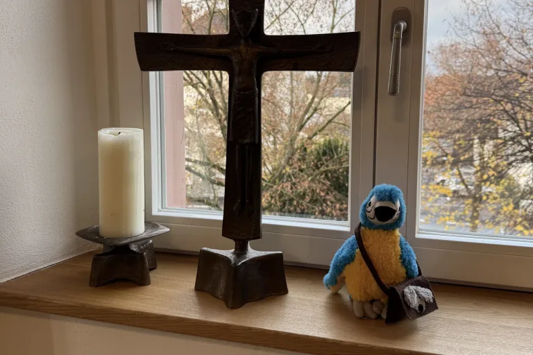 Fensterbank mit kleinem Holzkreuz, Kerze und einer Figur - Heiko Metz