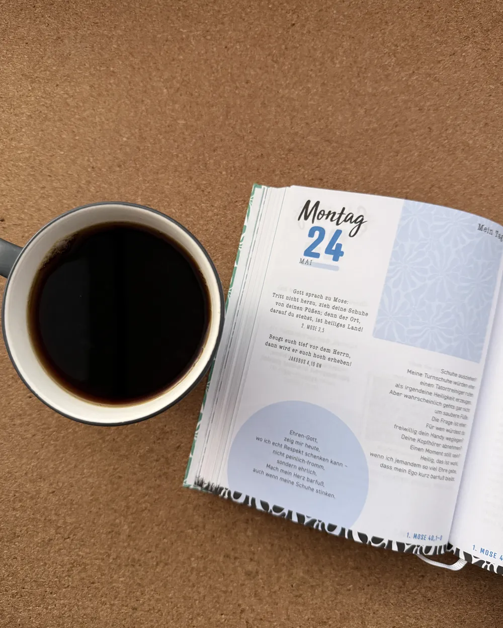 Tasse Kaffee neben einem aufgeschlagenen Andachtsbuch - Heiko Metz