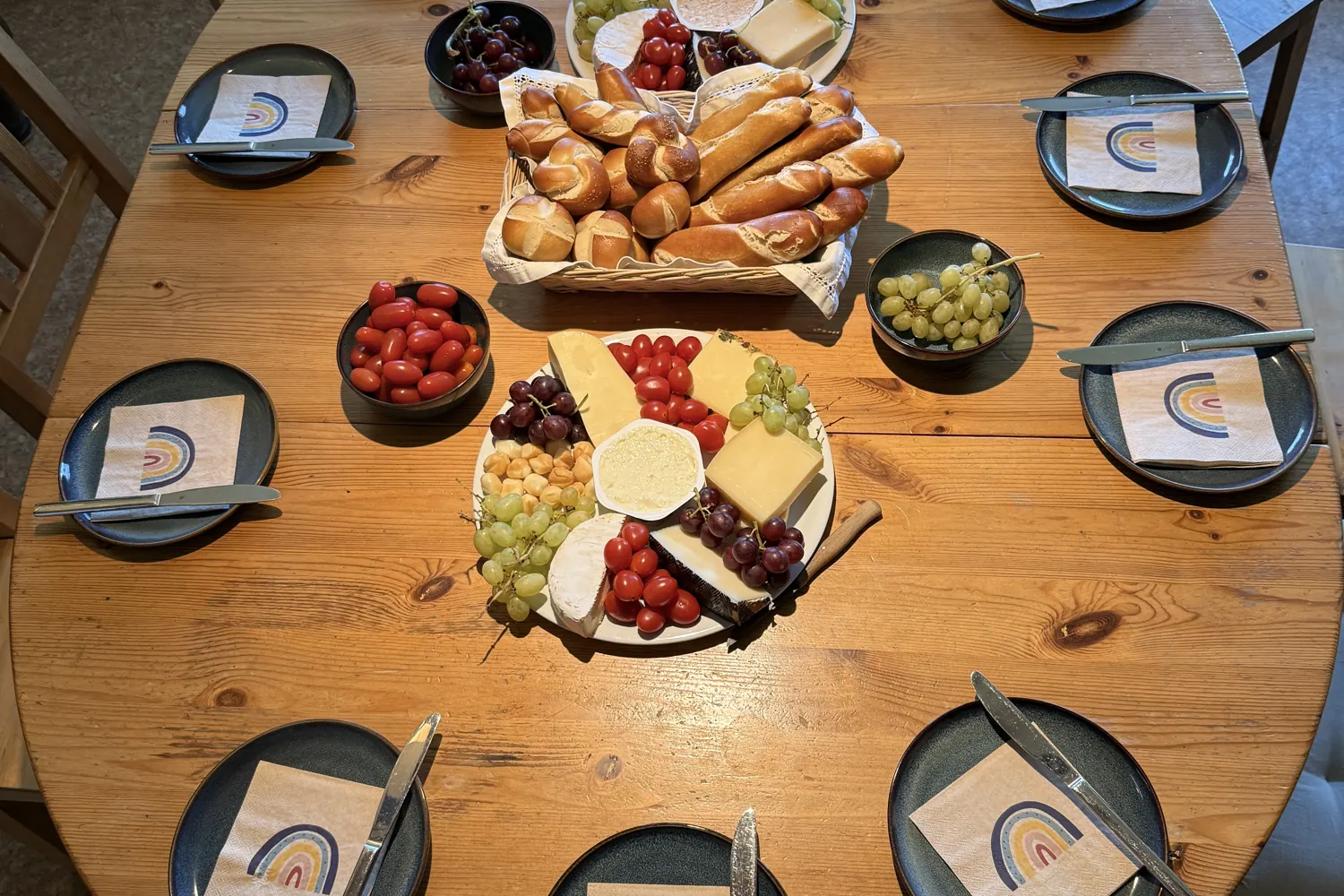 Gedeckter Tisch mit Brötchen, Käse und Obst von oben - Heiko Metz