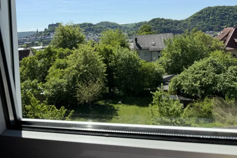 Blick aus dem Fenster auf Gärten und Hügel - Heiko Metz