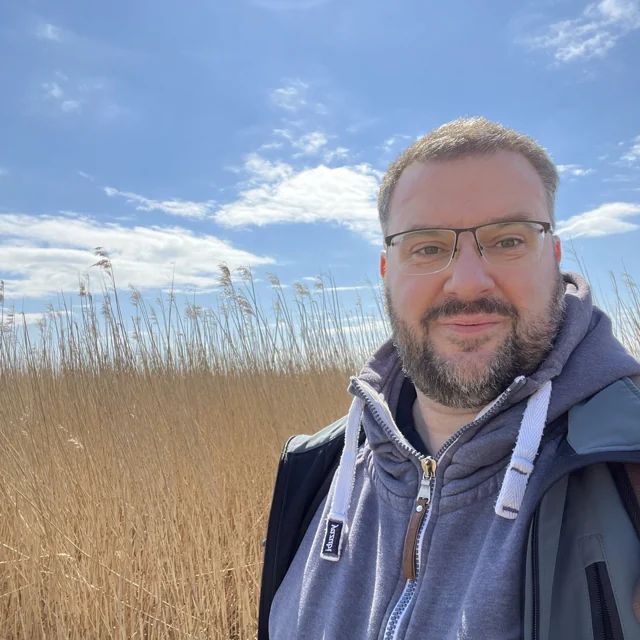 Heiko Metz im Schilf an der Küste, lächelnd - Heiko Metz