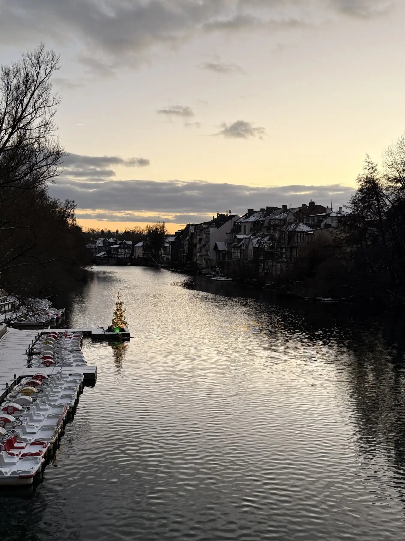 Abendhimmel über einem Fluss und den Dächern einer Stadt im Winter - Heiko Metz