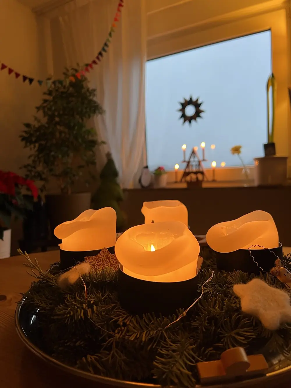 Adventskranz mit brennenden Kerzen und einem Stern am Fenster - Heiko Metz