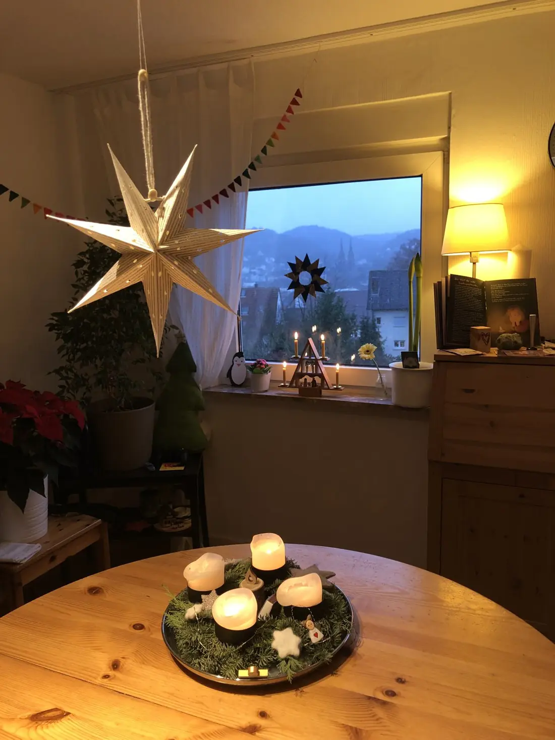 Fensterbank mit Adventskranz, Sternen und brennenden Kerzen am Abend - Heiko Metz